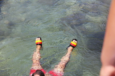 Low section of man swimming in lake