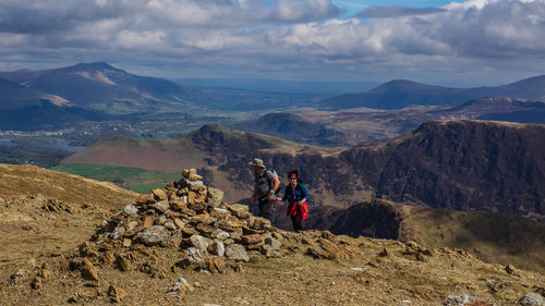 Rear view of people on mountain against sky