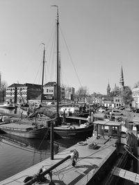 Sailboats moored at harbor against clear sky