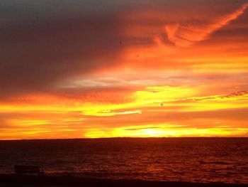 Scenic view of sea against dramatic sky during sunset