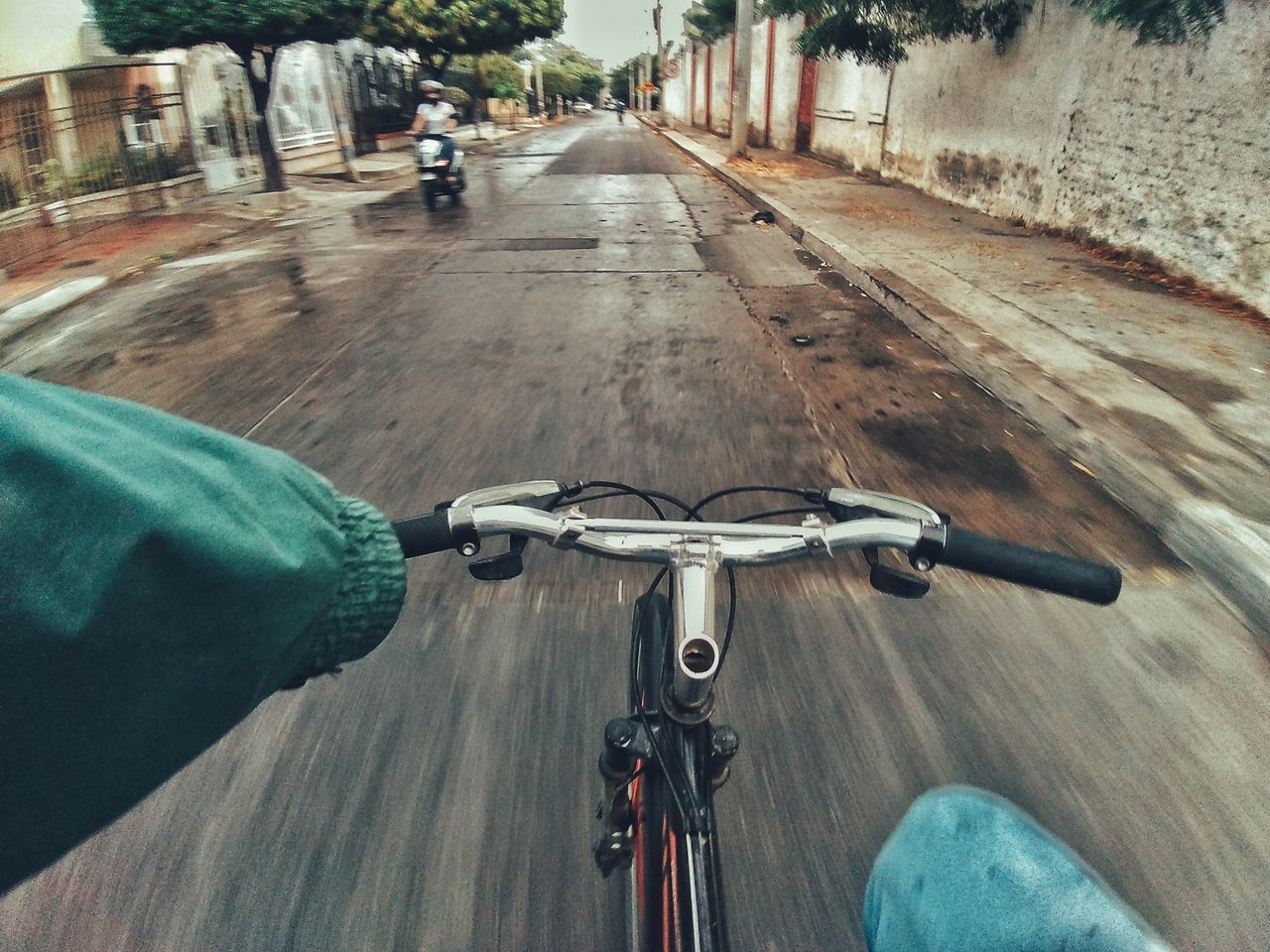 PERSON RIDING BICYCLE ON ROAD IN CITY