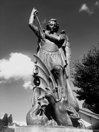 Low angle view of angel statue against cloudy sky