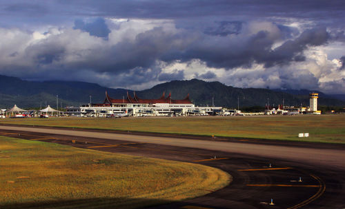 View of airport runway against cloudy sky