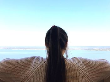 Woman looking at sea against clear sky