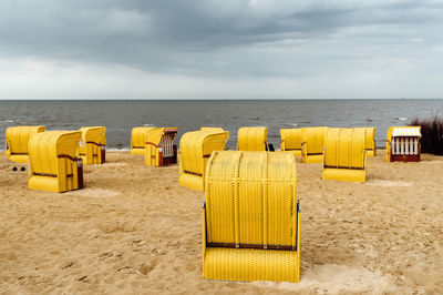 Sandy beach and typical hooded beach chairs in cuxhaven in the north sea coast, cloudy day of summer