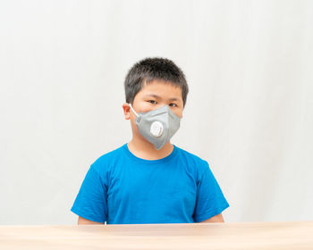 Portrait of boy against blue wall