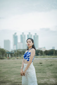 Portrait of young woman standing on field