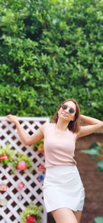 Full length of young woman with arms raised in park