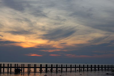 View of pier on calm sea at sunset