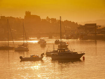 Boats on river during sunset 