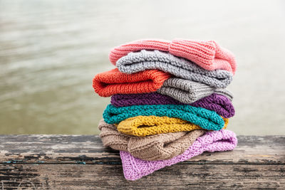 Rows of colorful knitted hats for sale on natural background.