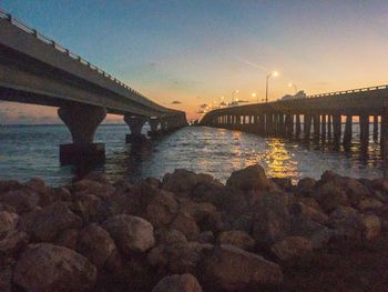 Bridge over river against sky during sunset