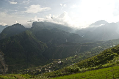 Scenic view of mountains against cloudy sky