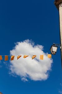 Low angle view of hanging lights against blue sky