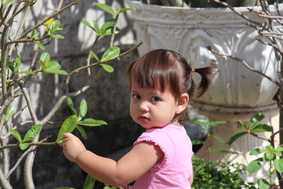 Close-up portrait of cute boy against plants