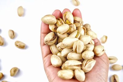 High angle view of hand holding eggs over white background