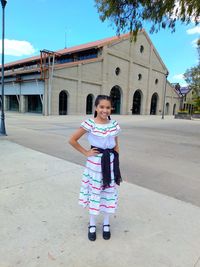 Portrait of girl standing against built structure