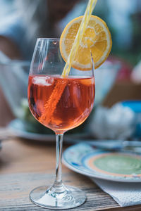 Close-up of wine glass with cocktail and drinking straw on table