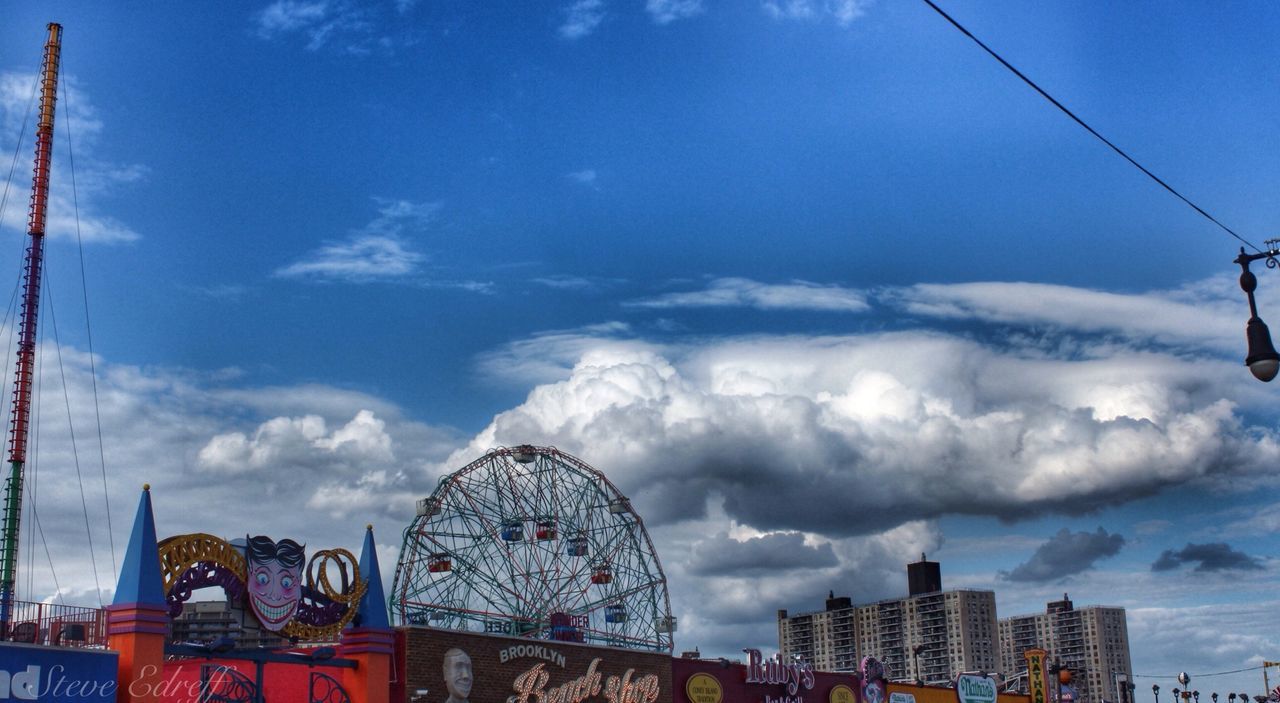 sky, architecture, built structure, cloud - sky, building exterior, low angle view, cloudy, cloud, city, blue, outdoors, day, no people, residential building, travel destinations, residential structure, cityscape, amusement park, building, metal