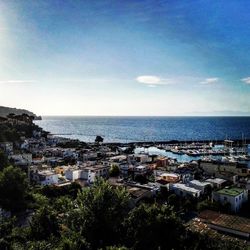 Cityscape by sea against sky