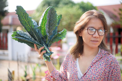 Portrait of young woman with eyeglasses in plant