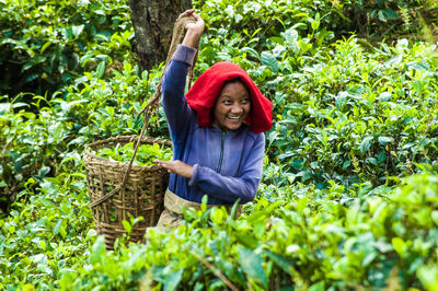 Portrait of smiling woman standing against plants