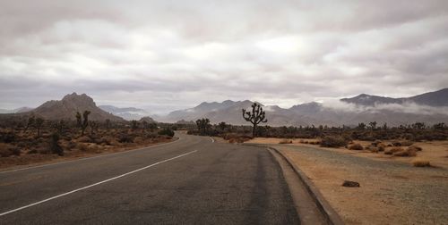 Empty road with mountains in background