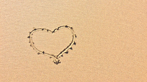 High angle view of heart shape on sand at beach