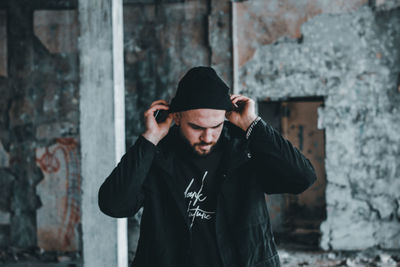 Young man standing against wall