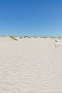 White sand dunes in desert against clear blue sky, western sahara