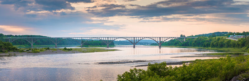 Bridge over river against sky during sunset