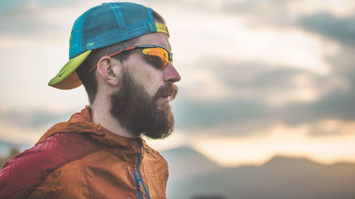 Sporty man with beard and hat in the mountains