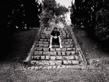 Girl standing on steps against trees