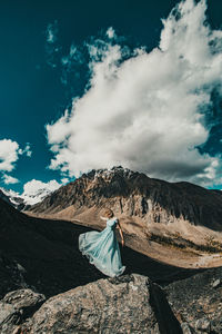 Man on rock against sky