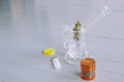 Close-up of on cannabis plant and grinder on table