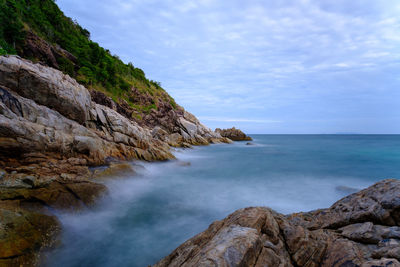 Rock formations by sea against sky