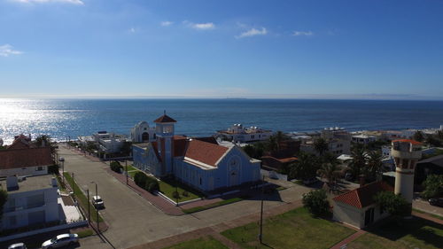 High angle view of buildings by sea against sky