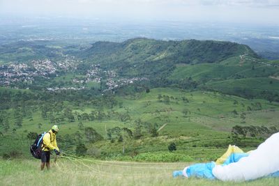 Rear view of man on field against mountain