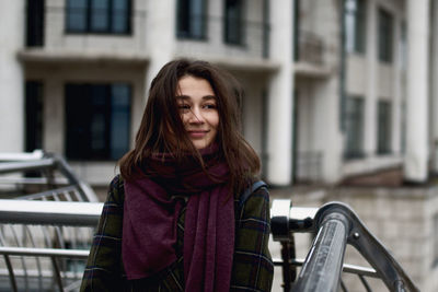 Portrait of beautiful young woman standing in the city and smiling