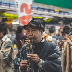 Close-up man playing flute in city