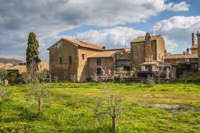 Old building by field against sky