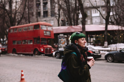 Portrait of non-binary female hipster standing on street in city