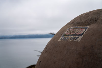 Close-up of text on beach against sky