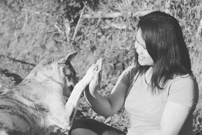 Dog giving high-five to smiling woman