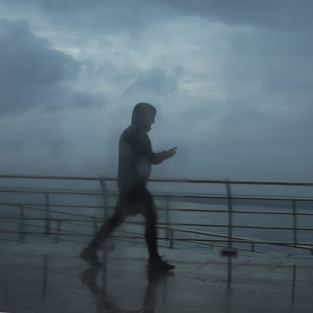 SILHOUETTE MAN STANDING ON RAILING AGAINST SKY