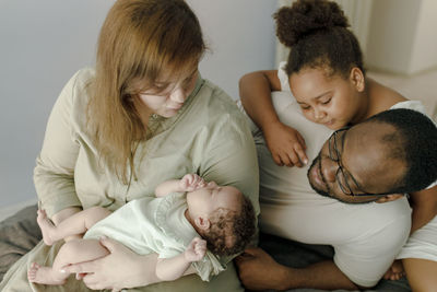 Happy family embracing baby girl at home