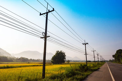 Electricity pylon on field against sky