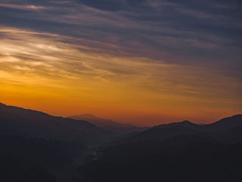 Scenic view of silhouette mountains against sky during sunset