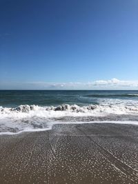 Scenic view of beach against clear blue sky