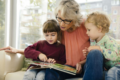 Pre-school teacher reading with children in kindergarten